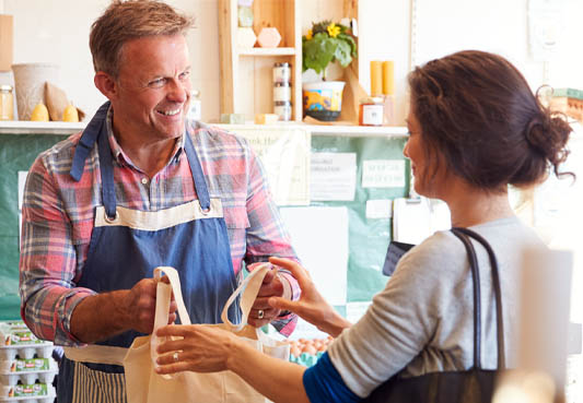 worker handing shopping bag to customer