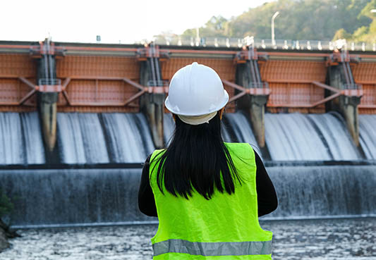 worker looking out at dam