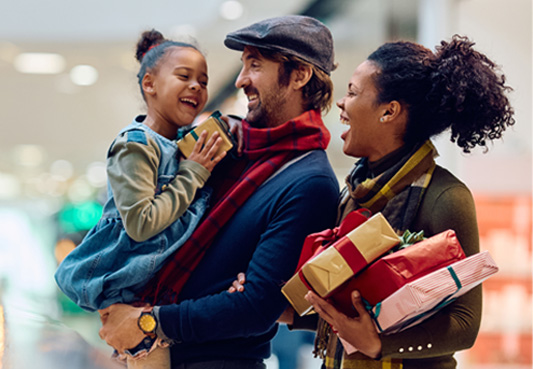 parents holding gifts and smiling at child