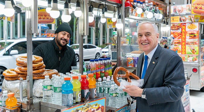   New York State Comptroller Thomas P. DiNapoli purchasing a pretzel from a NYC street vendor